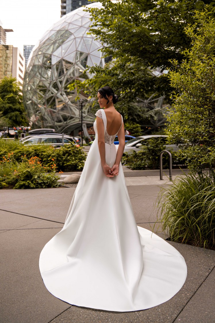 An unsurpassed minimalist wedding dress with winged straps and a train skirt is a true masterpiece of elegance.-5
